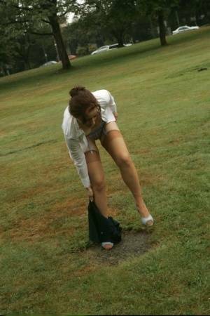 Amateur chick Dirty Angie strips to her pretties and tan nylons in a park on leakfanatic.com