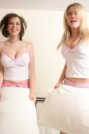 Young blonde Brooke Little and a girlfriend expose their big naturals on a bed on leakfanatic.com