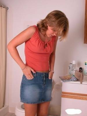 Amateur girl Karen hikes her denim skirt in the bathroom to expose her panties on leakfanatic.com