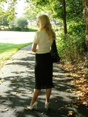 Clothed blonde Iona shows off her white stilettos in a long skirt by a park on leakfanatic.com