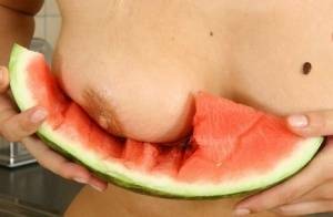 Blonde vixen Flower undressing in the kitchen to eat melon with bare big tits on leakfanatic.com