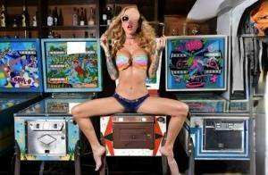 Inked chick Sarah Jessie toys her pussy atop a pinball machine while alone on leakfanatic.com