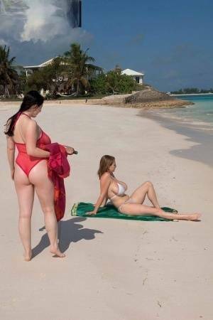 Busty lesbian girls let their huge knockers loose to kiss & lick on the beach on leakfanatic.com