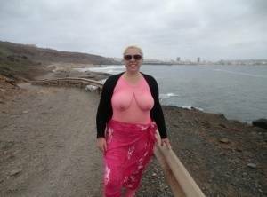 Aged lady Barby looses her big tits from a crotchless bodystocking by the sea on leakfanatic.com