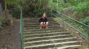 Natural redhead Chrissy Fox squats for a pee on a set of public steps on leakfanatic.com