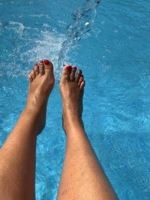 Mature woman Sweet Susi dips her painted toenails into a swimming pool on leakfanatic.com