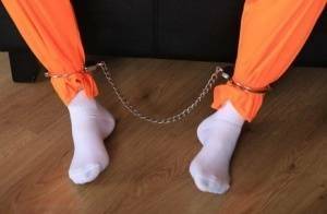 Female prisoner is left alone while cuffed in an orange jumper and white socks on leakfanatic.com