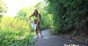 Blonde teen Daisy Lee takes a piss on a paved path through the woods on leakfanatic.com