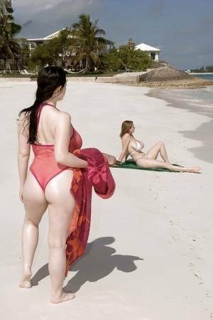 Fervent lesbians stripping nude and playing with dildos on the beach on leakfanatic.com