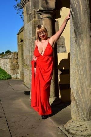 Older blonde Barby Slut doffs a red evening gown to pose nude in hosiery on leakfanatic.com