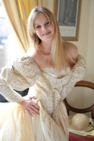 Blonde girl Rose takes off her petticoat to model in a girdle and nylons on leakfanatic.com